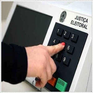 Pessoa digitando em uma urna eletrônica da Justiça Eleitoral